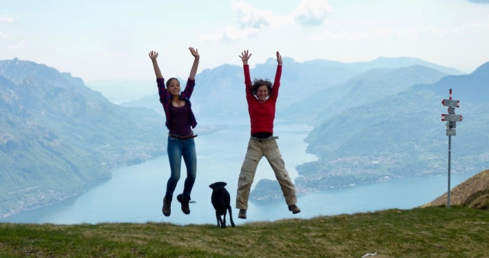 8 2-Frauen-mit-Hund-springen-vor-Bergpanorama