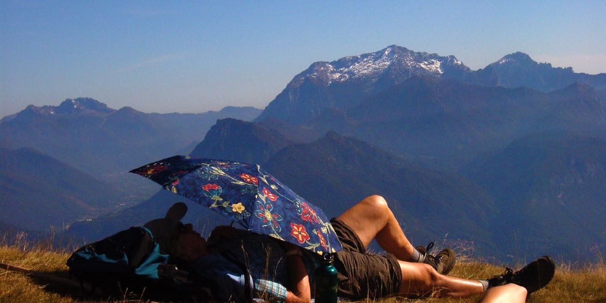 Frau-geniesst-die-Sonne-bei-einer-Wanderpause-im-Urlaub-am-Comer-See-in-Italien